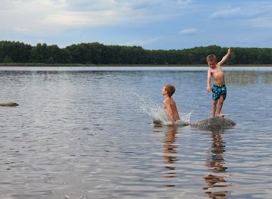 Kinder am Stein im See